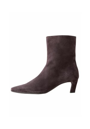 Stivaletto in suede grigio con punta affusolata e tacco basso, caratterizzato da una superficie liscia e un design minimalista senza hardware visibile.