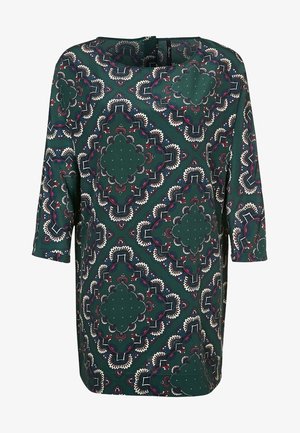 Mørkegrøn kjole med symmetriske store blomster- og geometriske mønstre i hvid, marineblå og rød, med trekvartærmer og rund halsudskæring.