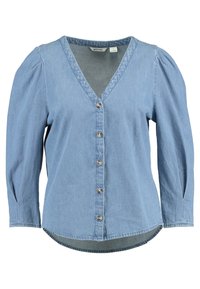 Blusa in denim blu chiaro con scollatura a V, maniche a sbuffo lunghe, chiusura frontale con bottoni e orlo arrotondato. Texture liscia con dettagli minimi.