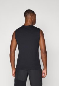 Svart ermeløs skjorte, rund hals, laget av bomull, med en jevn tekstur. Plagget har en slim fit og en enkel design.