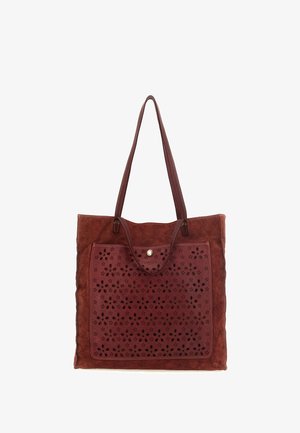 Borsa tote in pelle marrone con grande motivo floreale intagliato al laser sulla tasca frontale e doppi manici a spalla.