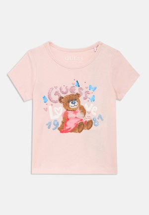 Różowy bawełniany T-shirt z ilustracją misia z kokardką. Napis z brokatem "Guess Love 1981" oraz drobne motylki. Krótkie rękawy.