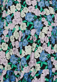 Robe florale en tissu noir ornée de fleurs bleues, blanches et violettes avec des feuilles vertes, cintrée à la taille, avec des détails à volants en couches.