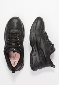 Scarpe sportive nere con tomaia in pelle texture e mesh, dotate di collare imbottito, lacci e suola ammortizzata per il massimo comfort.