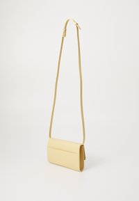 Bolso cruzado de cuero amarillo con forma rectangular, correa ajustable delgada y tapa frontal. Textura suave y diseño minimalista.