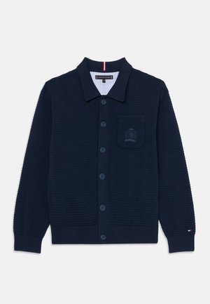 Cardigan en tricot marine avec un design à col, doté d'une fermeture à boutons, d'une texture côtelée et d'une poche poitrine avec un logo brodé.