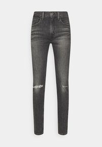 Černé skinny džíny s vybledlým vzhledem, obsahující dvě přední kapsy, jednu zadní kapsu a opotřebované detaily na kolenou.
