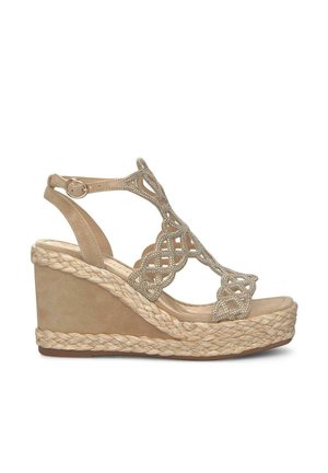 Beige wedge sandal with braided jute midsole, decorative cutouts, and accents. Smooth texture with a subtle sheen, adjustable ankle strap.