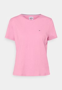 Vaaleanpunainen puuvillapaita, jossa on lyhyet hihat, pyöreä kaula-aukko ja päällekirjaillut logo rinnassa. Pehmeä rakenne ja rento istuvuus.