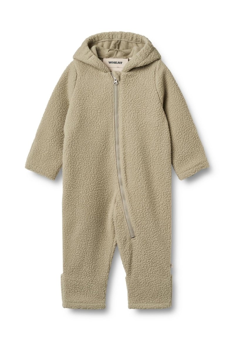 Combinaison en polaire de couleur beige clair avec fermeture éclair à l'avant et capuche. Elle possède des manches longues et des poignets aux chevilles, et présente une texture douce dans l'ensemble.