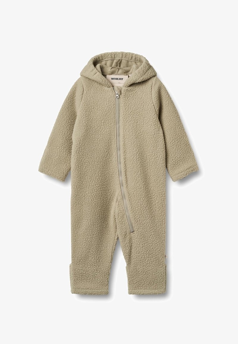 Fleece'owy kombinezon w jasnym beżu z zamkiem błyskawicznym z przodu oraz kapturem. Ma długie rękawy i mankiety na kostkach, miękka tekstura na całej powierzchni.