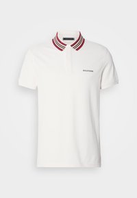 Polo blanc avec un col côtelé rayé rouge et beige. Comprend une encolure à boutons et "HILFIGER" brodé en bleu marine sur la poitrine.