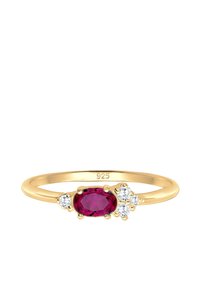 Anillo de plata de ley chapado en oro con una piedra central ovalada de rubí, flanqueada por dos acentos redondos de circonita cúbica a cada lado.