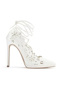 White high-heeled shoe with cut-out floral detailing, pointed toe, and lace-up design. Leather material with smooth texture.