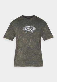 Mørkegrå acid-wash t-shirt med korte ærmer og hvid grafik af en pigtråds-oval, der omkranser et stiliseret Nike swoosh på fronten.