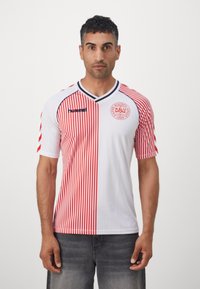 Men's short-sleeve jersey with a V-neck, featuring red vertical stripes on one side, and a white background. Logo on the chest, contrasting accents.