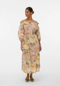Robe florale décolletée en tissu léger avec des teintes pastel de rose, jaune et vert. Encolure élastiquée, manches bouffantes et taille ceinturée.