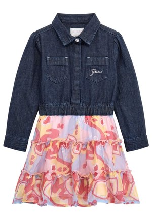 Jeansjacke mit langen Ärmeln und Brusttaschen über einem mehrfarbigen pastellfarbenen Rüschrock mit abstrakten rosa, gelben und lavendelfarbenen Mustern.
