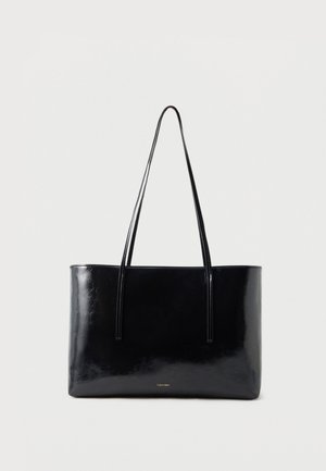 Bolso tote rectangular negro brillante con correas largas para el hombro, diseño minimalista y pequeño logo dorado en el centro inferior.