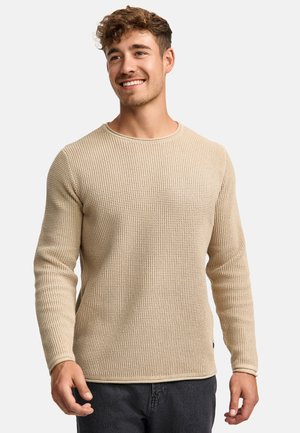 Beige neulepusero, jossa on teksturoitu kuvio, pyöreä kaula-aukko ja pitkät hihat. Sisältää hienovaraisen helmayksityiskohdan ja hieman vartalonmyötäisen muodon.