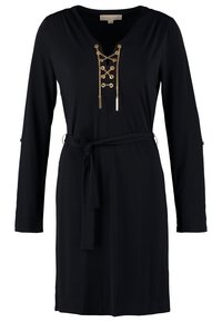 Svart långärmad klänning med V-hals, prydd med guldlänk och snörningsdetalj samt ett tygbälte i midjan. Slät textur, knälång klippning.