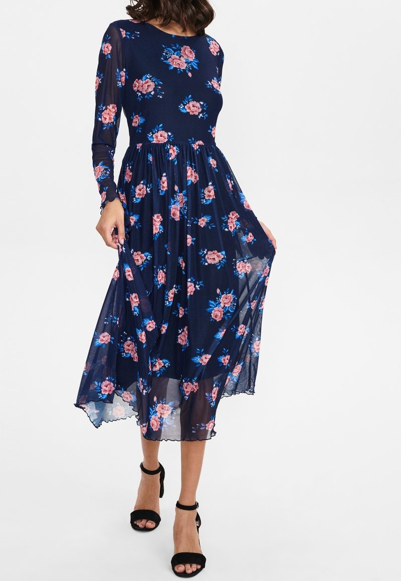 Vestido midi floral en azul marino con mangas largas transparentes, que presenta rosas rosas y acentos azules, un corpiño ajustado y un dobladillo acampanado.
