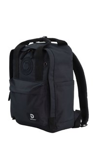 Zaino nero realizzato in tessuto resistente, dotato di spallacci regolabili, tasca frontale, dettaglio con logo circolare e cuciture rinforzate per una maggiore robustezza.