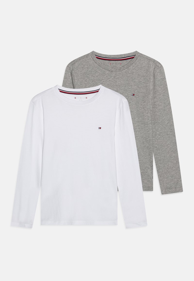 Två långärmade t-shirts med rund halsringning, en vit och en grå, var och en med en liten röd, vit och blå logotyp på vänster bröst.
