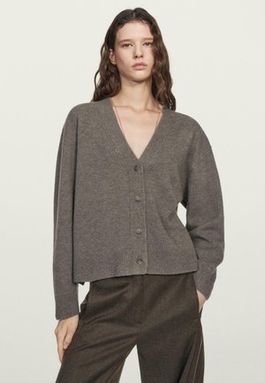 Cardigan grigio a scollo a V con vestibilità comoda e chiusura con cinque bottoni. Presenta polsini e orlo a coste, realizzato in un morbido tessuto lavorato a maglia con texture.