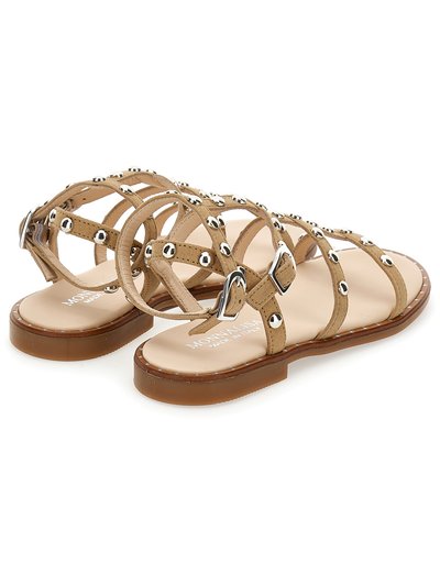 Sandalias de ante en tono marrón con diseño de tiras entrelazadas, adornos de tachuelas plateadas, suela plana y cierre de hebilla ajustable para un ajuste seguro. Construcción ligera.