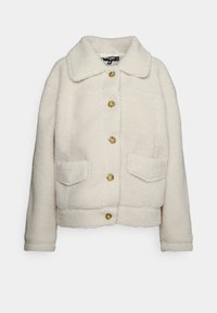 Jasno kremowa kurtka z polaru sherpa, z dużym kołnierzem, pięcioma guzikami w kolorze muszli żółwia oraz dwiema kieszeniami z klapką z przodu.