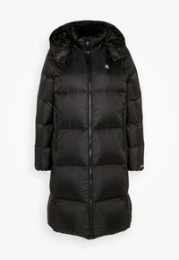Black long puffer coat with a hood, featuring quilted sections, a front zipper, and side pockets. Logo on the upper left side.