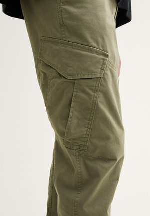 Pantalons cargo vert olive en tissu durable, dotés de poches latérales et d'une coupe décontractée. La texture semble lisse avec des détails de couture.