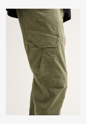 Olivově zelené cargo kalhoty vyrobené z odolné látky, s bočními kapsami a volným střihem. Textura vypadá hladce s detaily šití.