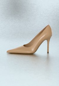 Escarpin beige unique à talon haut avec bout pointu et talon stiletto fin, posé sur une surface lisse gris clair.