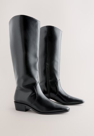 Cizme negre până la genunchi, din piele ecologică, cu vârf ascuțit și toc gros, prevăzute cu fermoar lateral și textură netedă. Design unghiular în partea superioară.