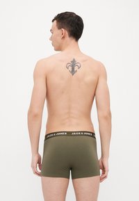 Boxers verts olive avec une ceinture noire arborant le logo "JACK & JONES". Modèle présenté de dos, affichant un tatouage sur le haut du dos.