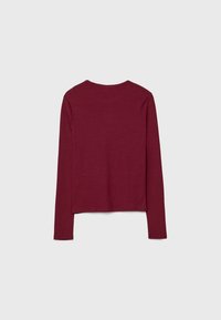 Bordeaux rood shirt met lange mouwen, gemaakt van zacht gebreid stof. Heeft een ronde halslijn en een rechte zoom. Geen zichtbare patronen of versieringen.