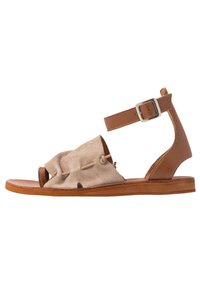 Tan leather sandal with a beige suede upper, open toe, adjustable ankle strap, and decorative stitching. Flat sole.