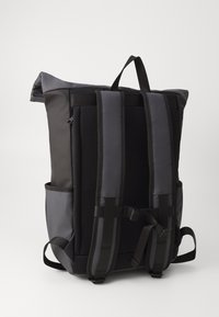 Black roll-top backpack with a gray panel, padded mesh back, adjustable straps, and side pockets. Features minimalistic design and sturdy fabric.