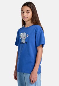 Blå bomulds t-shirt med et grafisk design af en elefant og ordet "ELEMENT" nedenfor. Korte ærmer og en afslappet pasform.