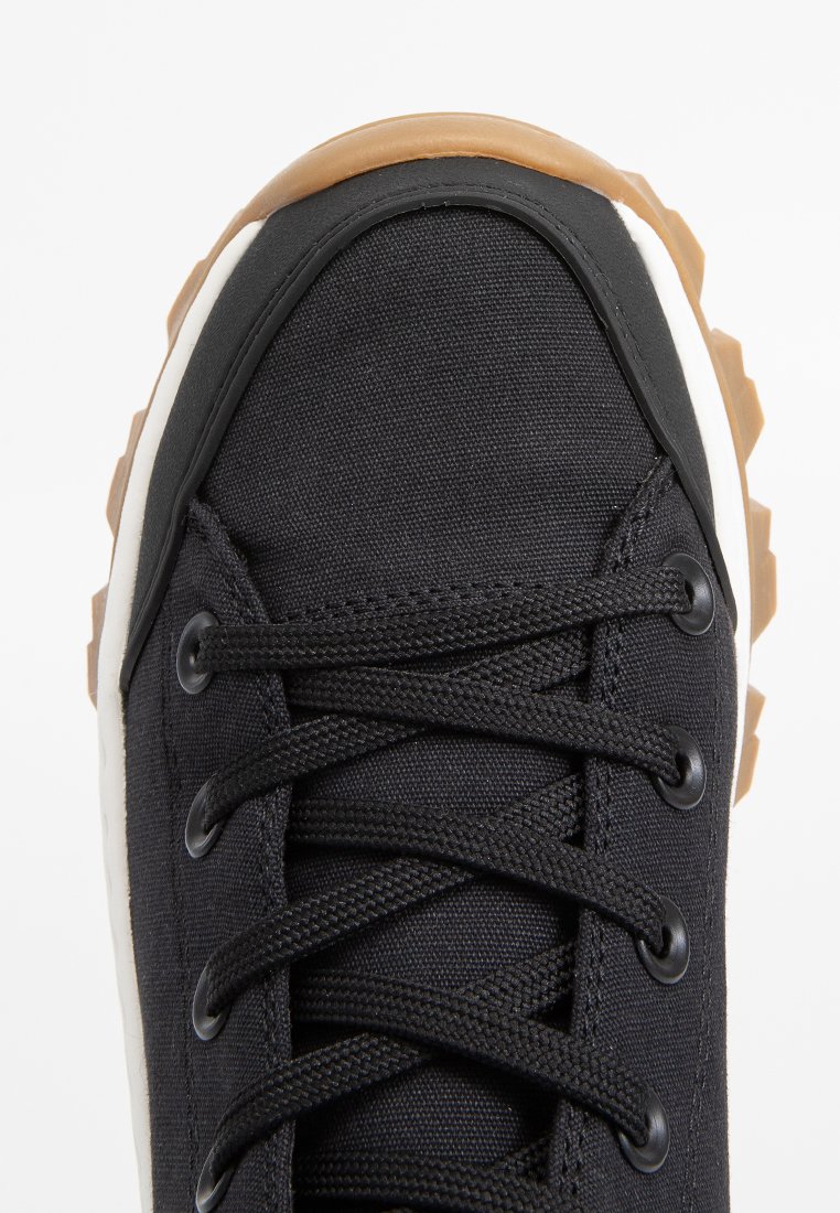 Schwarze Leinensneaker mit klobiger Gummisohle, runden Schnürsenkeln, verstärkter Zehenkappe und weißen Mittelsohlenakzenten. Strukturiert Oberfläche.