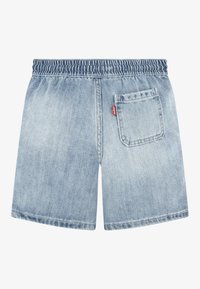 Jeansshorts, ljusblå med elastisk midja. Har en bakficka med en röd logotypetikett. Rak skärning och slät textur.