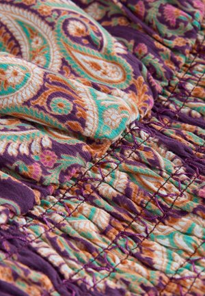 Lila szövet narancssárga és zöld paisley mintával. Összegyűrt textúra, látható varrással, amely részletet és dimenziót ad.