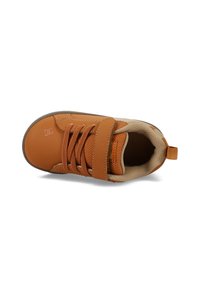 Hnedé tenisky s suchým zipsom, sieťovaným jazykom a okrúhlou špičkou. Majú textúrovaný povrch a jemné logo na boku.