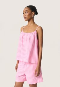 Conjunto de pijama a rayas rosas hecho de tela ligera, que incluye una parte superior sin mangas con tirantes ajustables y pantalones cortos a juego con una cinturilla elástica.