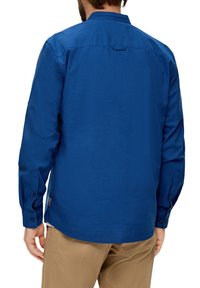 Blauwe lange-mouwen shirt, textuurstof, met een kraag, knoopmanchetten en een rechte zoom. Heeft een rugstuk detail.