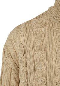 Pulover bej din tricot cu model împletit reliefat, guler înalt cu nervuri și material texturat. Accent pe detaliile de la umăr și guler.