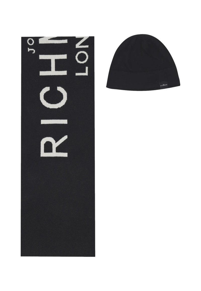 Sciarpa nera lavorata a maglia con grandi scritte bianche "RICH" e berretto nero con un'etichetta marchiata. Entrambi gli articoli hanno una texture liscia.