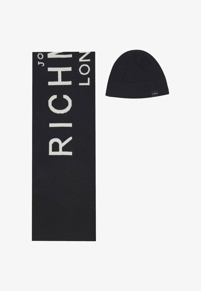 Sciarpa nera lavorata a maglia con grandi scritte bianche "RICH" e berretto nero con un'etichetta marchiata. Entrambi gli articoli hanno una texture liscia.